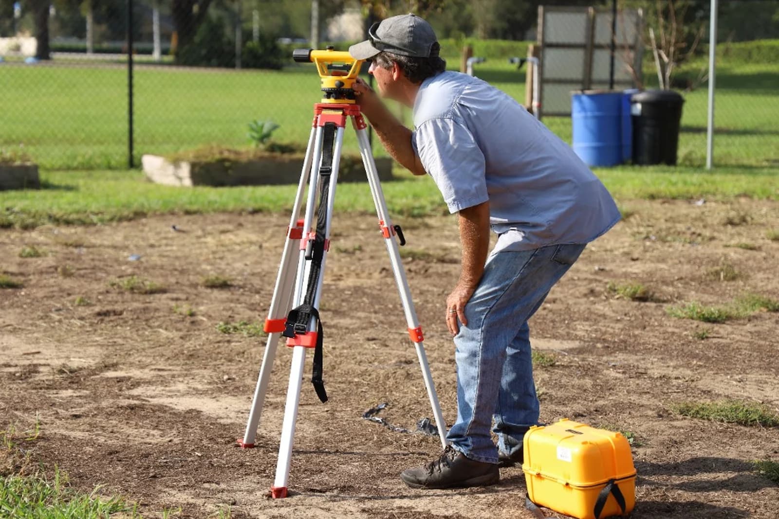 Technician with surveying equipment working outdoors.
