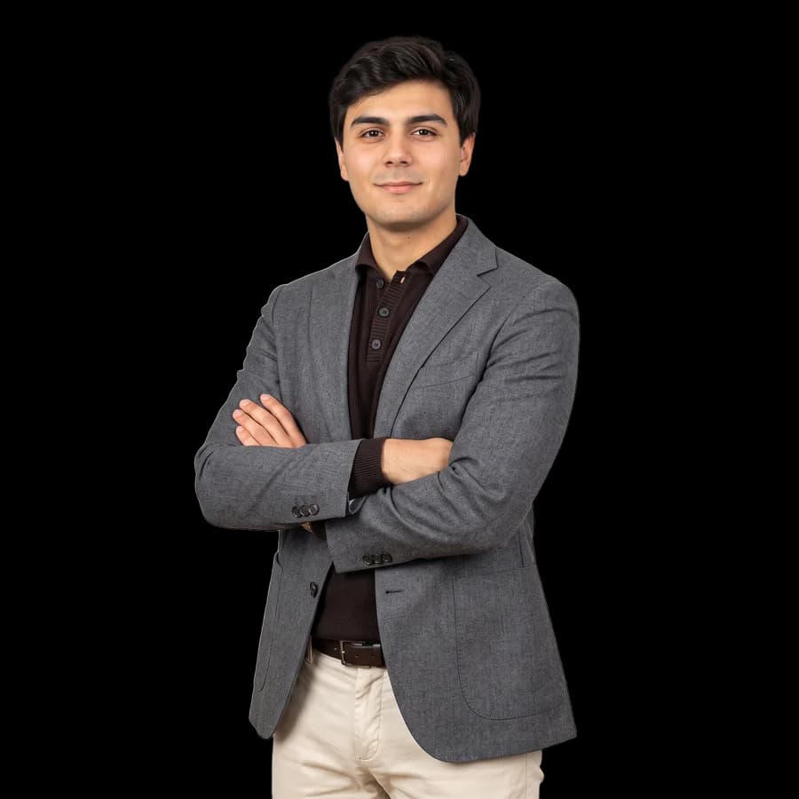 Daniel González, de pie y con los brazos cruzados, con pelo castaño oscuro, americana gris, polo de punto marrón y pantalón claro.